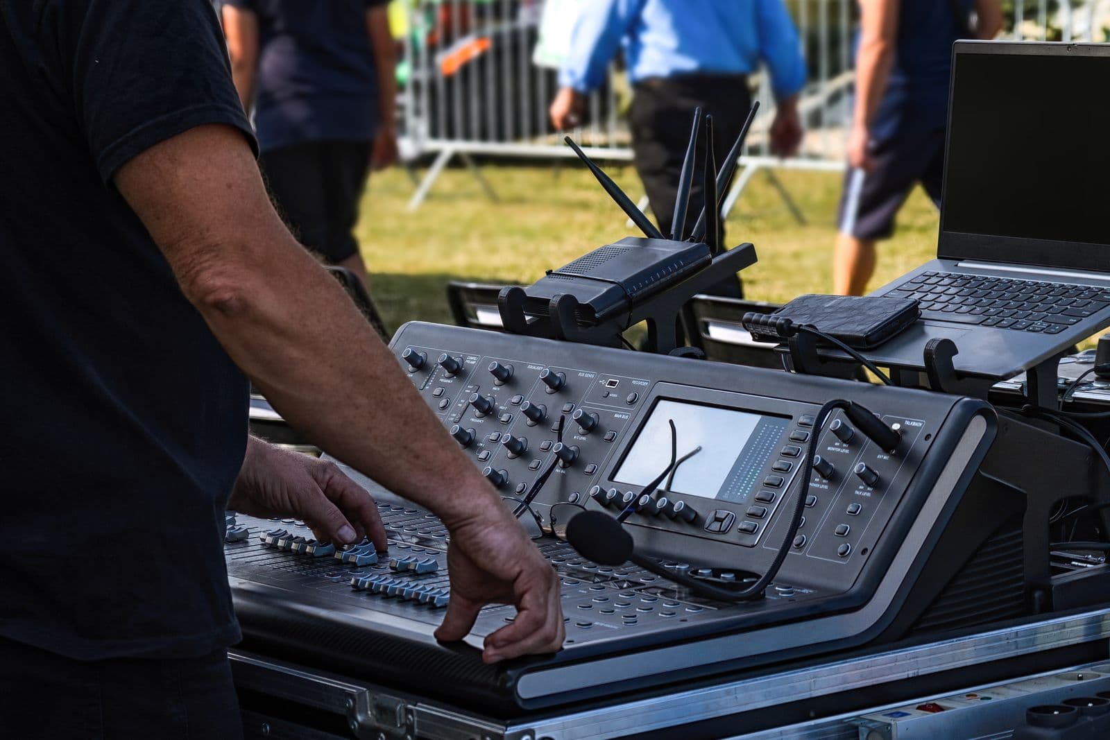 Audio engineer operating a professional mixing console at a live outdoor event